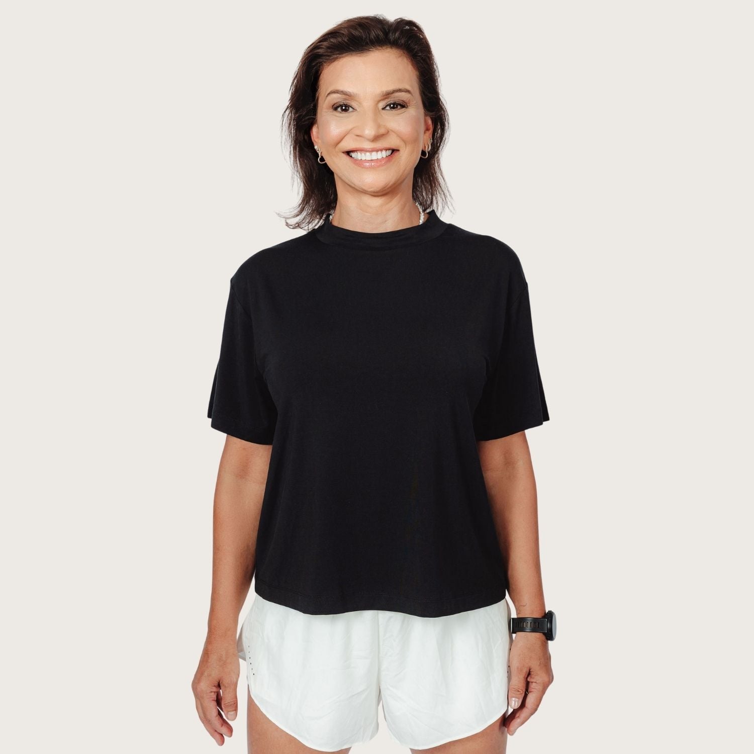 Woman wearing Lyvora Noir Breeze Tee front view — black breathable TENCEL™ Modal top