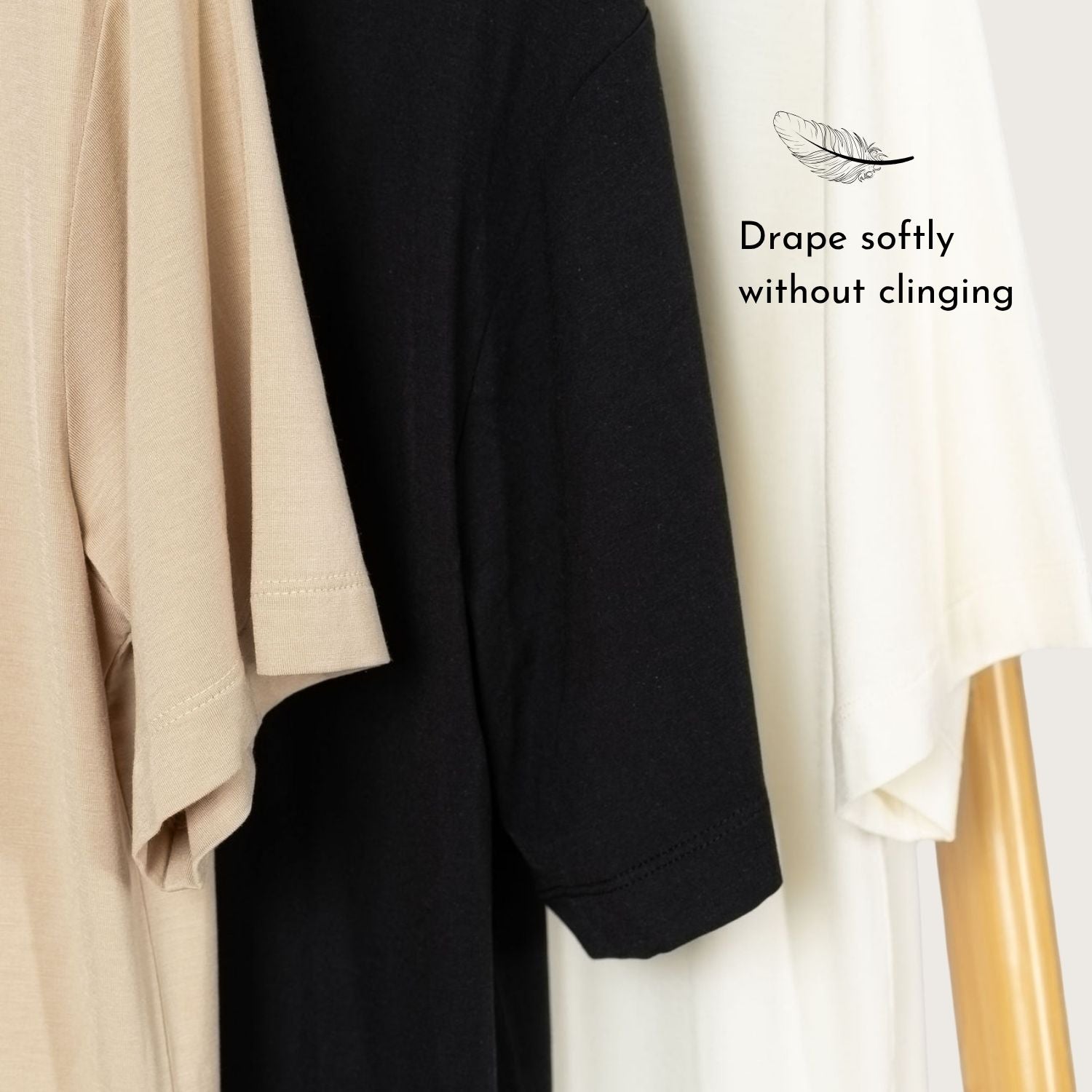 Lyvora tees in Sand Drift, Noir, and Moon Glow tones hanging side by side.